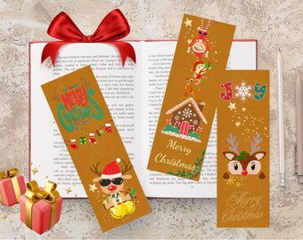 Puede incluir: Tres marcapáginas navideños con diseños festivos, incluyendo un reno con gafas de sol, una casa de jengibre y la palabra "Joy". Los marcapáginas están sobre un libro con un lazo rojo.