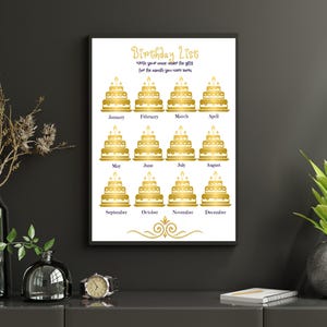 Könnte beinhalten: Gerahmter "Geburtstagsliste"-Druck mit goldenem Text und Kuchenillustrationen für jeden Monat. Der Druck wird auf einer dunkelgrauen Oberfläche angezeigt, mit einer Vase mit Trockenblumen, einer kleinen Vase, einer Uhr, einer Pflanze und einem Notizbuch.