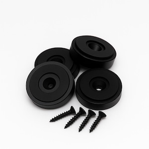 May include: A collection of black speaker isolation pads and screws. The pads are round with a recessed center and a flat base. The screws are black and have a pointed tip. The items are arranged on a white background.
