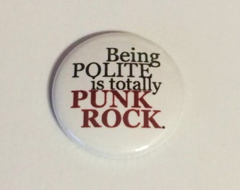 Puede incluir: Botón blanco con texto negro y rojo que dice "Being Polite is totally Punk Rock."