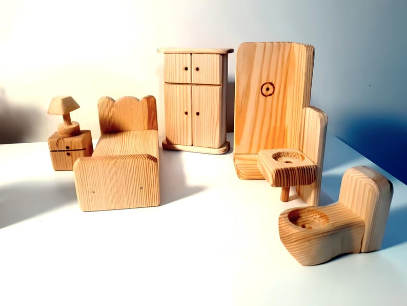 May include: A set of wooden dollhouse furniture, including a bed, a dresser, a nightstand with a lamp, a toilet, and a sink. The furniture is made of unfinished wood and is ready to be painted or stained.