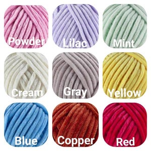 May include: Nine balls of yarn in different colours: powder pink, lilac, mint, cream, grey, yellow, blue, copper, and red.