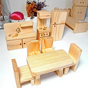 May include: A wooden dollhouse kitchen set with a sink, stove, refrigerator, table, and four chairs. The set is made of unfinished wood and is ready to be painted or stained.