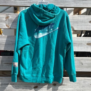 May include: A distressed wooden sign with the words "Welcome to our home" in white lettering. The sign has a rustic finish and a simple design, ideal for a front door or hallway.