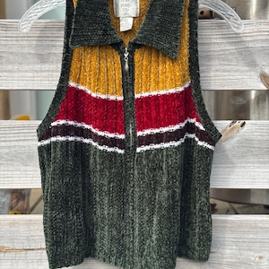 May include: A white ceramic mug with a black handle and the text "But First, Coffee" in a black, handwritten-style font. The mug is on a white surface.