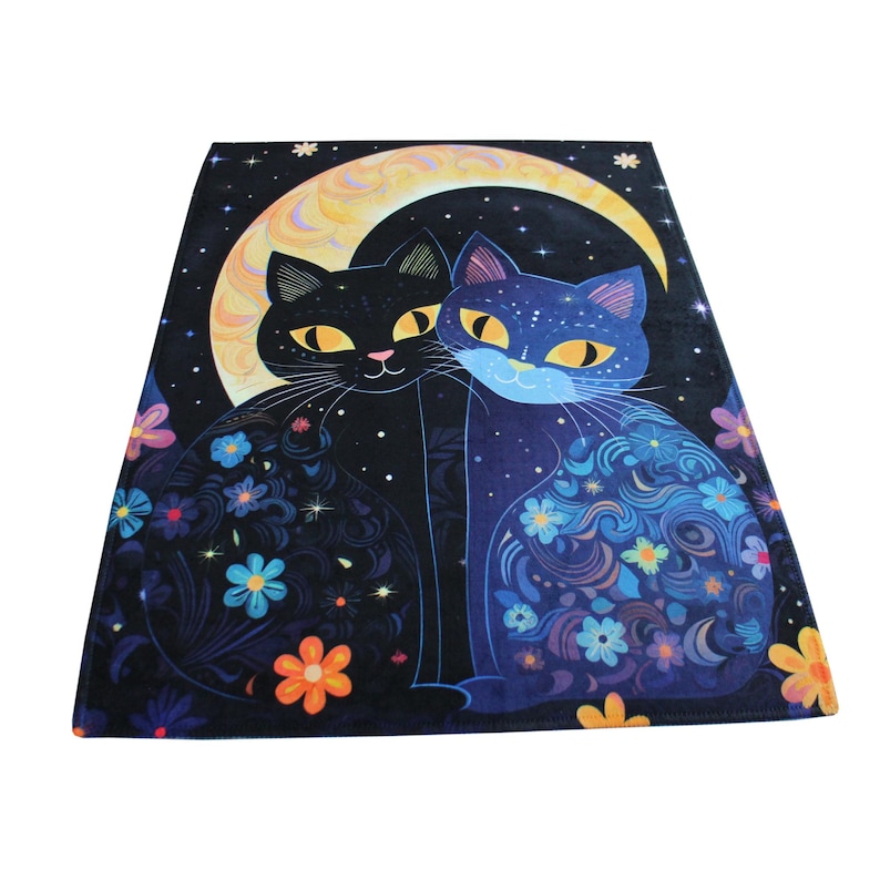 Pu&ograve; includere: Due gatti neri con occhi gialli si coccolano sotto una luna crescente. I gatti sono circondati da fiori colorati e stelle su uno sfondo nero.