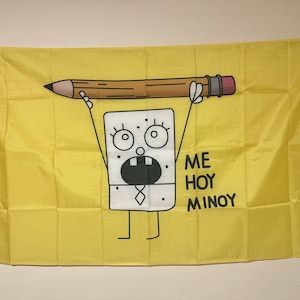 May include: A yellow flag with a cartoon character holding a pencil above its head. The character has a surprised expression and is wearing a tie. The text "ME HOY MINOY" is written below the character.