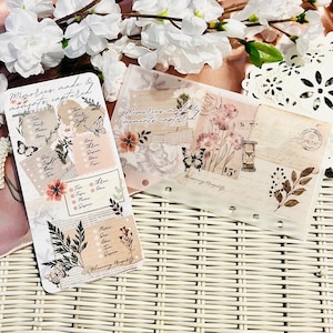 Puede incluir: Dos insertos de papel decorativos con diseños florales y de mariposas. Un inserto presenta una lista con casillas de verificación, el texto "Memories made & moments captured" e ilustraciones botánicas. El otro tiene una estética vintage.