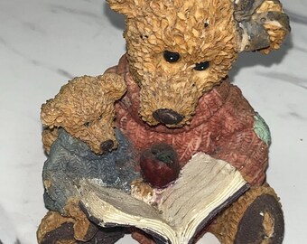 mother bear reading a book to his son, with an apple on the book