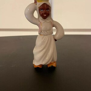vintage porcelain figurine of a woman carrying a basket on her head