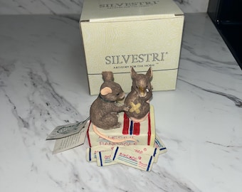 Colección Silvestri Mice Tails, que representa dos ratones y una caja de vendas adhesivas.