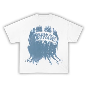 Puede incluir: Camiseta blanca con un dise&ntilde;o gr&aacute;fico azul que muestra la palabra "woman" en escritura cursiva. El dise&ntilde;o parece ser una representaci&oacute;n estilizada de cabello o una cabeza. La camiseta tiene cuello redondo y mangas cortas.