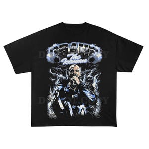 May include: Black t-shirt featuring a graphic of a man with the text "DRAKE The Iceman" in a stylized font. The graphic includes a portrait of the man and flame-like designs.