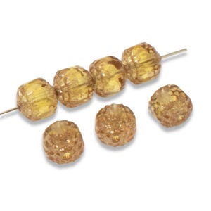May include: A strand of six amber glass beads with a textured surface. The beads are round and have a slightly irregular shape. Two additional beads are shown separately.