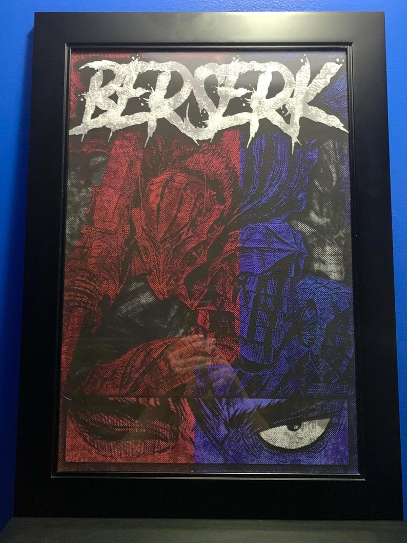 May include: A framed print of a black and white illustration of a character from the Berserk manga series. The character is wearing a large, horned helmet and armor. The title "BERSERK" is written in silver lettering at the top of the print.