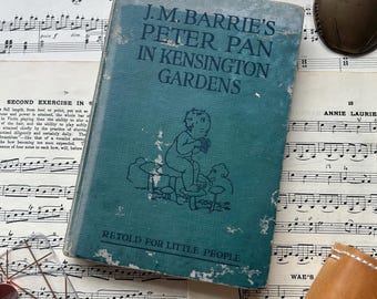 Antique Peter Pan in Kensington Gardens book. Old green cover, vintage book for display