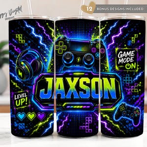 May include: A cylindrical tumbler featuring a black background with neon blue, green, and purple lightning, gaming controllers, headphones, and pixelated blocks. The name JAXSON is printed in large, bold letters, with text reading LEVEL UP and GAME MODE ON.