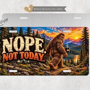 May include: A rectangular metal license plate featuring a graphic of a brown Bigfoot holding a steaming mug in a forest landscape with mountains at sunset. The text NOPE. NOT TODAY. is printed in large, distressed orange and white letters.