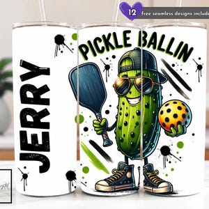 May include: A white tumbler featuring a cartoon pickle character wearing sunglasses and a cap, holding a pickleball paddle and ball. The text "PICKLE BALLIN" is above the pickle. The name "JERRY" is on the other side.