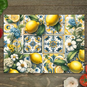 May include: A colorful kitchen cutting board with a lemon and floral design. The board features a blue and white tiled pattern with yellow lemons and white flowers.