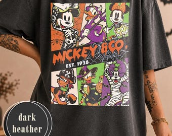 May include: A dark heather gray short-sleeve t-shirt featuring a graphic print of Disney characters in Halloween costumes. The design includes Mickey, Donald, Minnie, Pluto, Daisy, and Goofy with the text MICKEY & CO. EST. 1928 and spiderwebs.