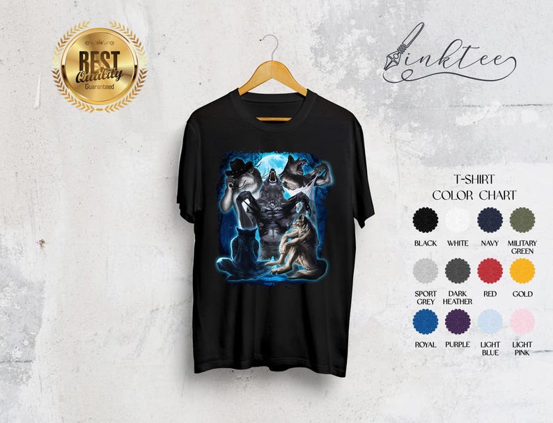 May include: Black t-shirt with a fantasy illustration of werewolves under a full moon. The graphic includes a central wolf figure and other wolf-like creatures. The shirt is displayed on a wooden hanger against a neutral background. Color chart included.