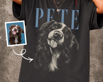 May include: A charcoal gray short-sleeve t-shirt featuring a large black and white graphic of a dog with its tongue sticking out. Above the dog, the name PETE is printed in large, light blue capital letters. A small photo of the dog is included.