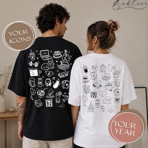 Könnte beinhalten: Ein schwarzes T-Shirt und ein weißes T-Shirt, beide mit einem Rückendruck aus verschiedenen weißen Strichzeichnungen wie Laptop, Katze, Pizza, Getränken und Spielkarten. Das schwarze Shirt zeigt den Text YOUR ICONS und das weiße Shirt YOUR YEAR.