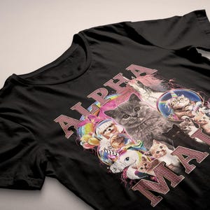 May include: Black t-shirt with a pink and white graphic print of cats and unicorns. The text "ALPHA MALE" is printed in pink on the shirt.