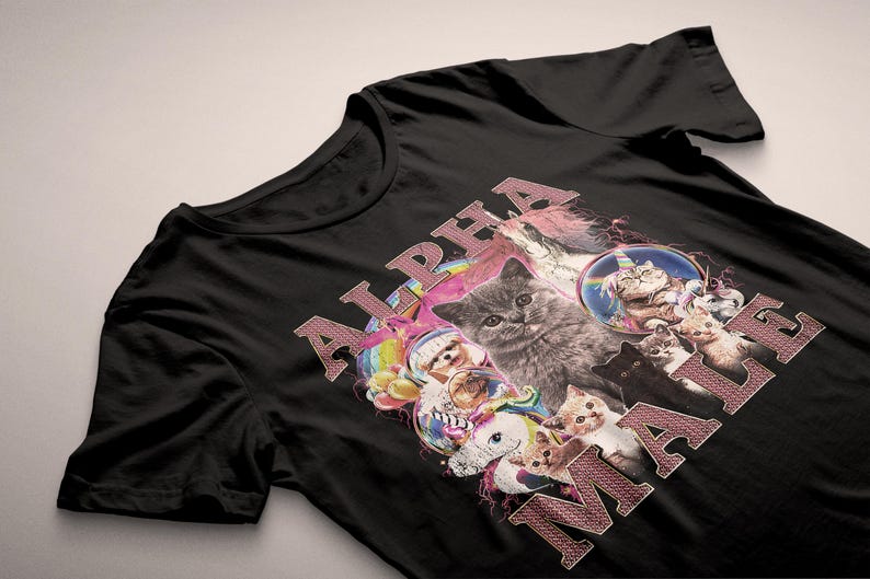 May include: Black t-shirt with a pink and white graphic print of cats and unicorns. The text "ALPHA MALE" is printed in pink on the shirt.