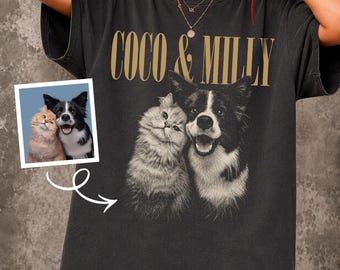 May include: A charcoal gray short-sleeve t-shirt featuring the gold text COCO & MILLY above a black and white graphic illustration of a cat and a dog. A small square inset shows the original color photograph of the same cat and dog.