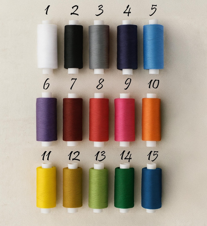 May include: Fifteen spools of thread in various colors, including white, black, gray, navy, and blue. Other colors include purple, red, pink, orange, yellow, green, and teal. Each spool is numbered from 1 to 15.