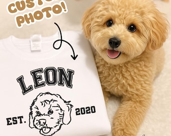 May include: White sweatshirt with the name "LEON" in black block letters, a dog illustration, and the text "EST. 2020." A light brown dog is next to the sweatshirt. The text "CUSTOM PHOTO!" is in a brown bubble.
