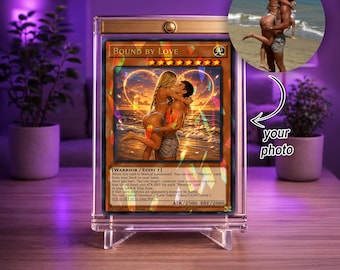 May include: A custom trading card titled Bound By Love encased in a clear acrylic magnetic display stand. The card features a romantic illustration of a couple embracing on a beach at sunset, with game text and stats printed below the image.