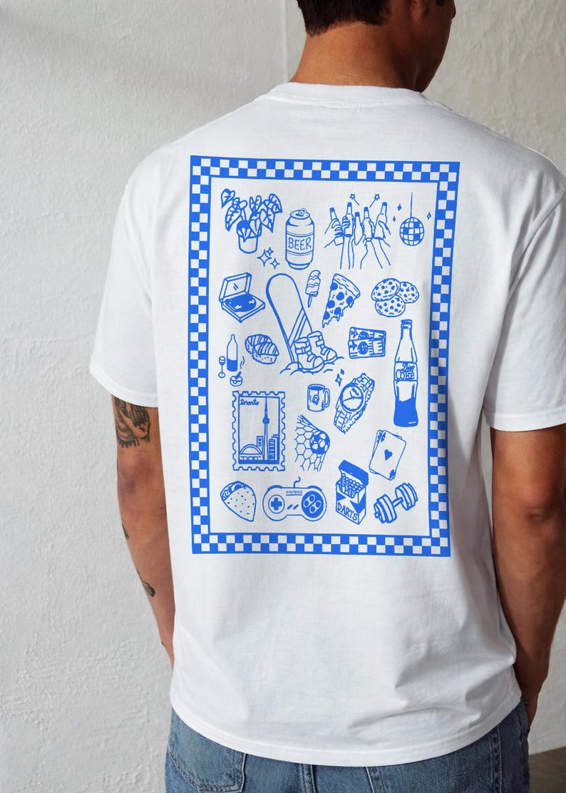 May include: White t-shirt with a blue checkered border and a blue graphic print on the back. The print features various illustrations, including a laptop, beer can, pizza slice, and a watch. The shirt is a casual, everyday wear item.