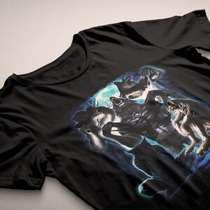 May include: Black t-shirt with a graphic of wolves howling at the moon. The design features a full moon and a blue and white colour scheme. The shirt is made of a soft material.