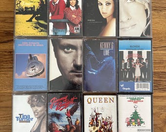 May include: A collection of twelve vintage cassette tapes featuring various artists and albums. The tapes showcase a variety of genres, including pop, rock, and jazz. Album covers include Sting, Carpenters, Celine Dion, Dire Straits, Kenny G, Blondie, Tina Turner, Jimmy Buffett, Queen, and Vince Guaraldi.