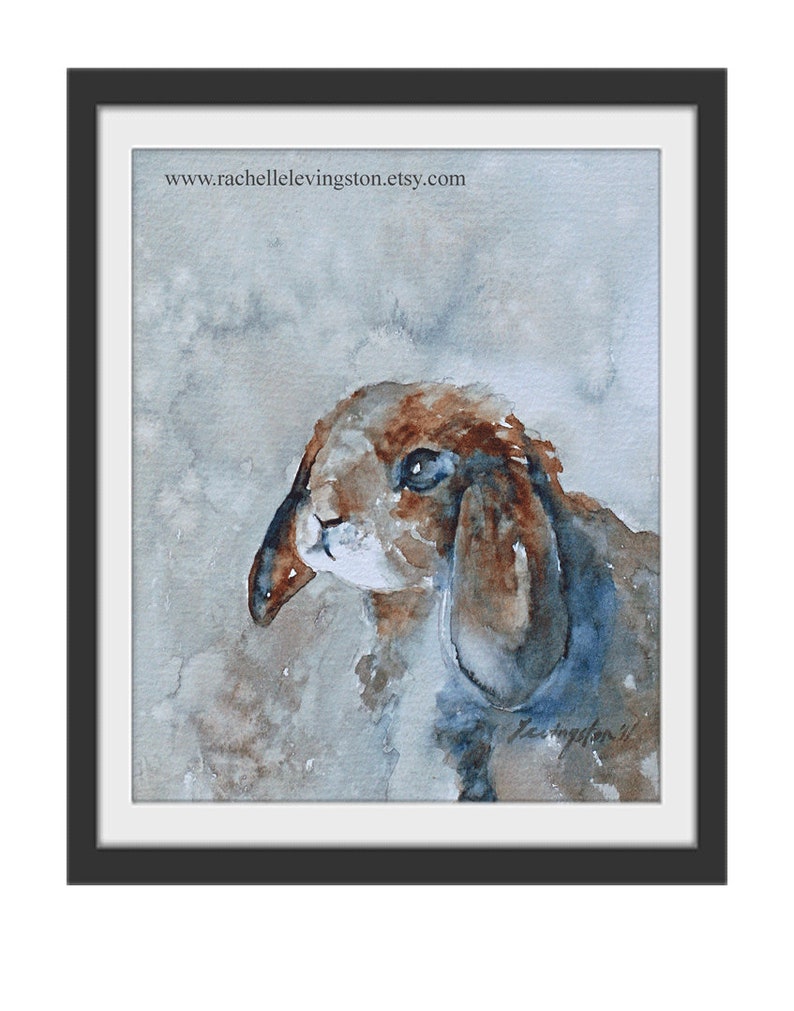 K&ouml;nnte beinhalten: Aquarellmalerei eines braunen und wei&szlig;en Kaninchens mit Schlappohren. Das Kaninchen schaut nach links aus dem Bild. Der Hintergrund ist hellblau mit braunen und grauen Aquarell-Waschungen.