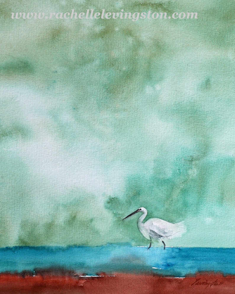 Puede incluir: Una pintura de acuarela de una garceta blanca de pie en un cuerpo de agua azul. El fondo es de un verde suave con nubes blancas.