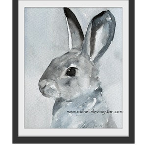 K&ouml;nnte beinhalten: Ein Aquarellbild eines grauen Kaninchens mit schwarzen Ohren und einer schwarzen Nase. Das Kaninchen schaut nach rechts im Bild. Der Hintergrund ist ein hellblauer Aquarell-Wasch. Das Bild ist unten rechts mit "Rachel" signiert und enth&auml;lt die Website "www.rachellelevingston.com".