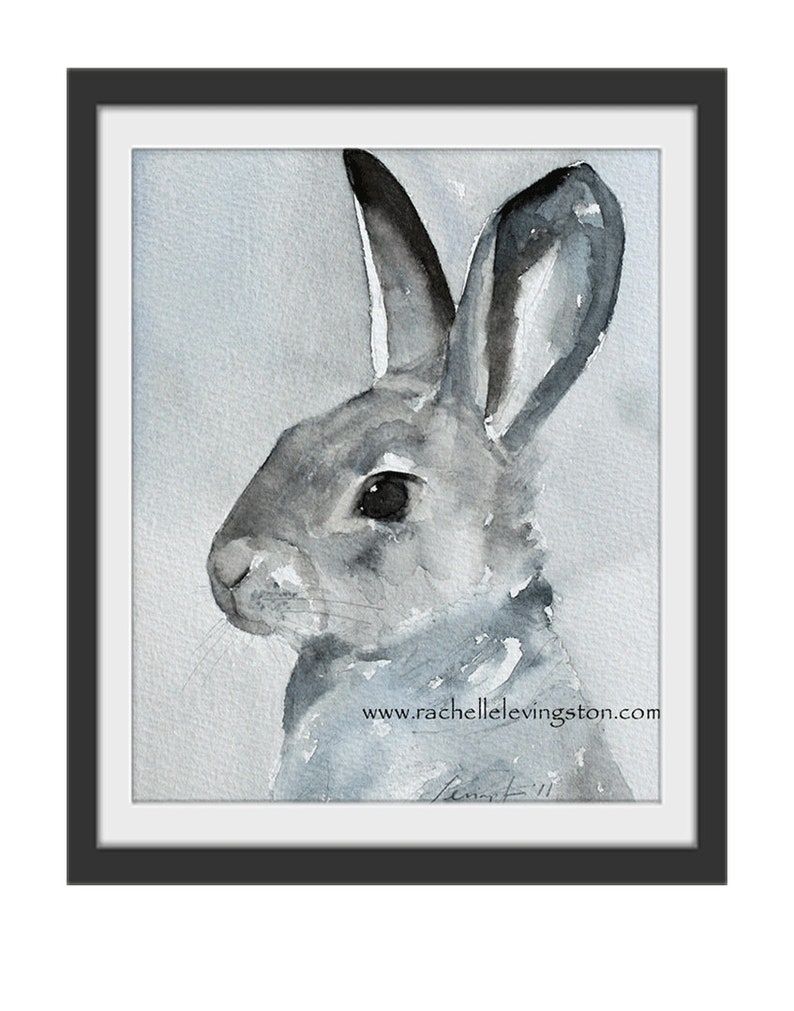 K&ouml;nnte beinhalten: Ein Aquarellbild eines grauen Kaninchens mit schwarzen Ohren und einer schwarzen Nase. Das Kaninchen schaut nach rechts im Bild. Der Hintergrund ist ein hellblauer Aquarell-Wasch. Das Bild ist unten rechts mit "Rachel" signiert und enth&auml;lt die Website "www.rachellelevingston.com".