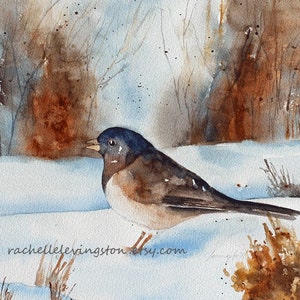 May include: Watercolor painting of a brown and blue bird perched on a snowy ground with brown brush in the foreground and a brown and blue background.