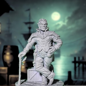 May include: A gray painted miniature figurine of a fantasy character with pointed ears, wearing a long coat and holding a walking stick. The figurine is posed with one leg crossed over the other and one hand on the hip. The figurine is standing on a small base.