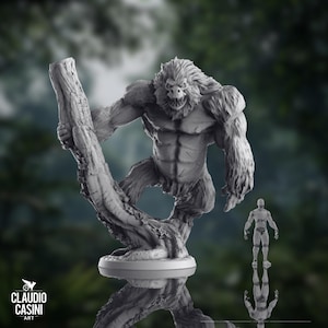 May include: A detailed gray sculpture of a large, muscular ape-like creature holding onto a tree branch. The sculpture has a menacing expression and is mounted on a round base. A smaller human figure is also present.
