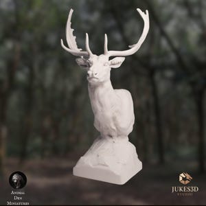 May include: A white, unpainted 3D printed miniature of a stag bust, featuring detailed antlers and a textured neck, mounted on a square base. The figure is presented with the text Animal Den Miniatures and Jukes3D Studio visible at the bottom.
