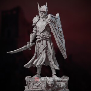Op de afbeelding: Een wit, gedetailleerd, 3D-geprint miniatuur van een ridder in harnas met een zwaard en schild. De ridder draagt een helm met een schedelvormig gezicht en een lange, vloeiende mantel. Het miniatuur staat op een voetstuk met een schedelontwerp.