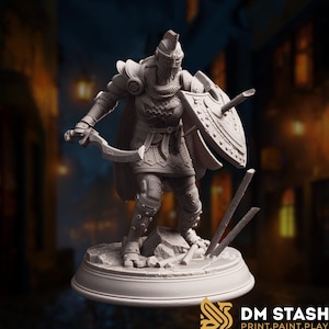 Puede incluir: Miniatura gris detallada de un guerrero con armadura completa, sosteniendo una espada curva y un escudo con una flecha incrustada. La figura está sobre una base rocosa con lanzas rotas. La base tiene el texto "DM STASH PRINT.PAINT.PLAY."