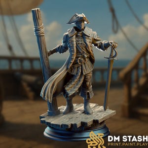 May include: A detailed figurine of a pirate, wearing a tricorn hat and long coat, holding a sword and standing next to a wooden post. The figure is on a wooden platform with a black base, set against a blurred ship and sky background.