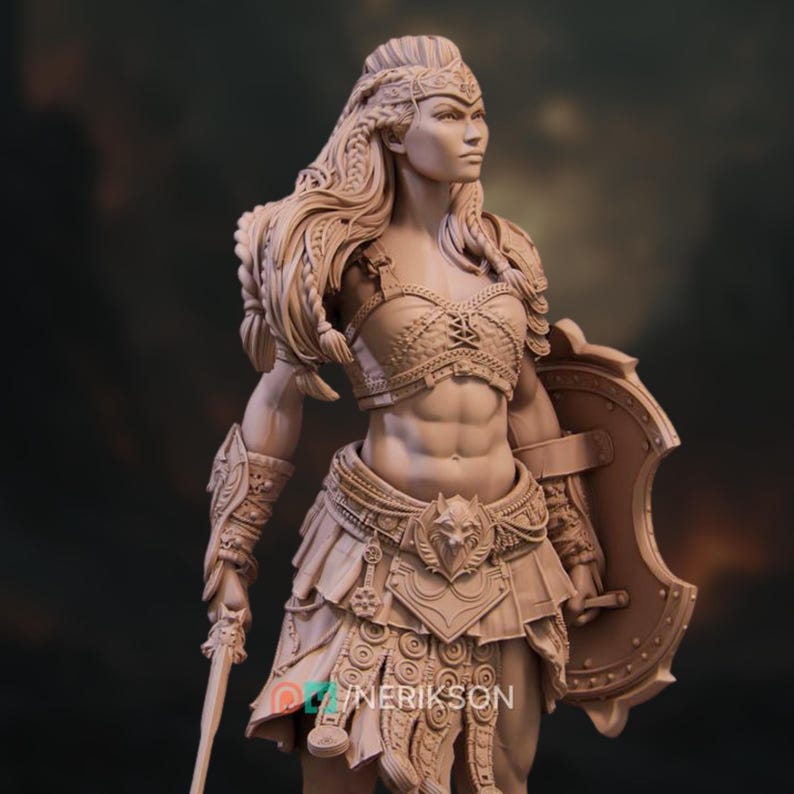 May include: A detailed sculpture of a warrior woman, clad in ornate armor and holding a sword and shield. The figure has long braided hair and is adorned with intricate designs. The sculpture is in a neutral color, highlighting the details of the armor and the warrior's physique.