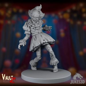 Puede incluir: Una figura gris impresa en 3D de un payaso amenazante con ropa hecha jirones, cuello con volantes y una sonrisa siniestra. La figura está sobre una base circular, con el logo "Vault Z" visible. El fondo está borroso con luces de colores.